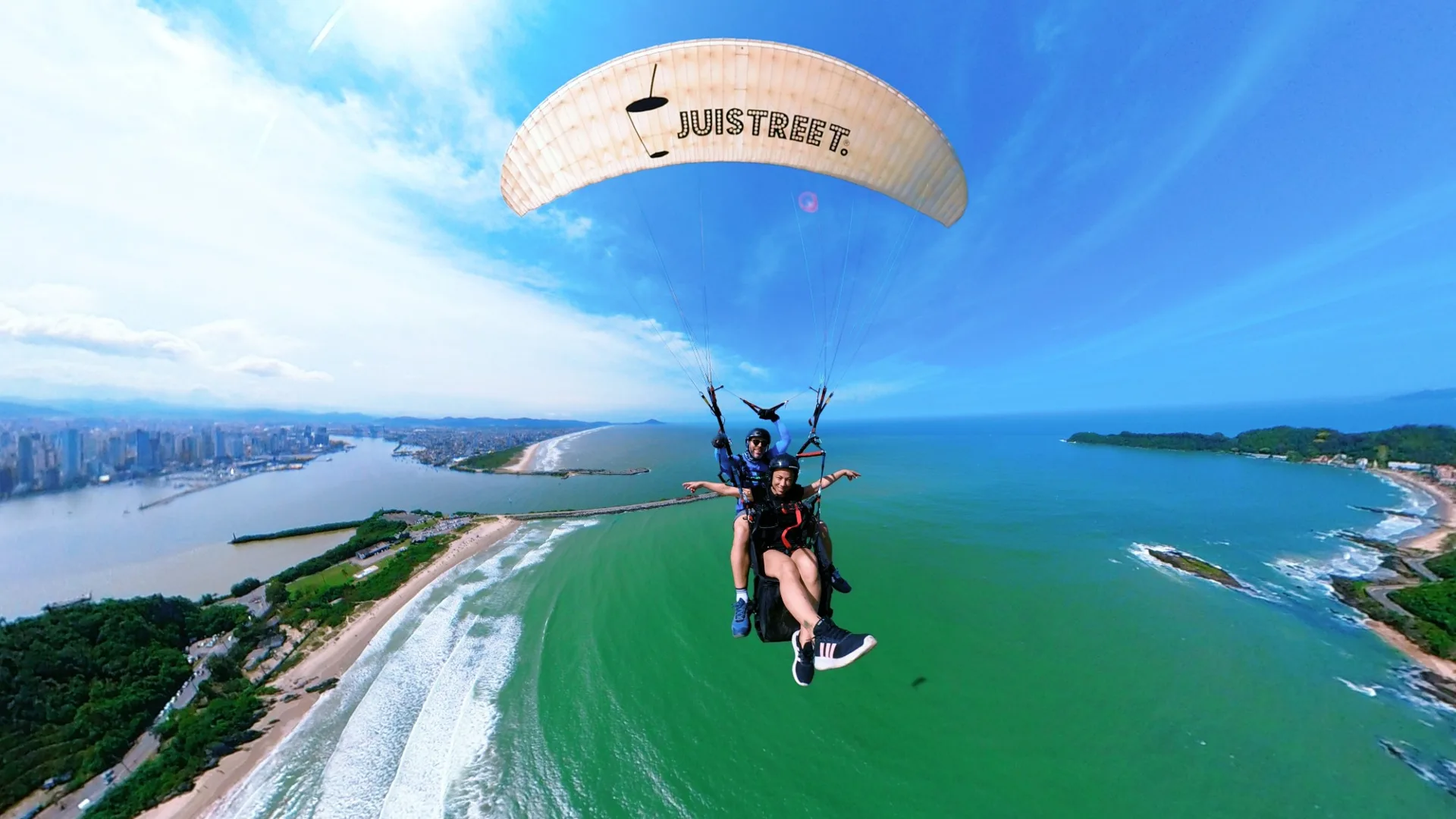 Voo duplo de parapente sobre a foz do rio Itajaí e o mar verde